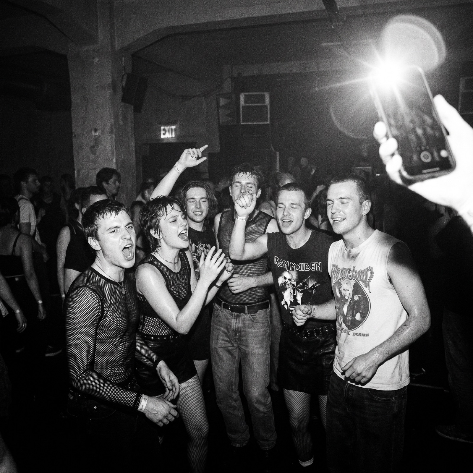 Black-and-white flash photo on a packed dance floor